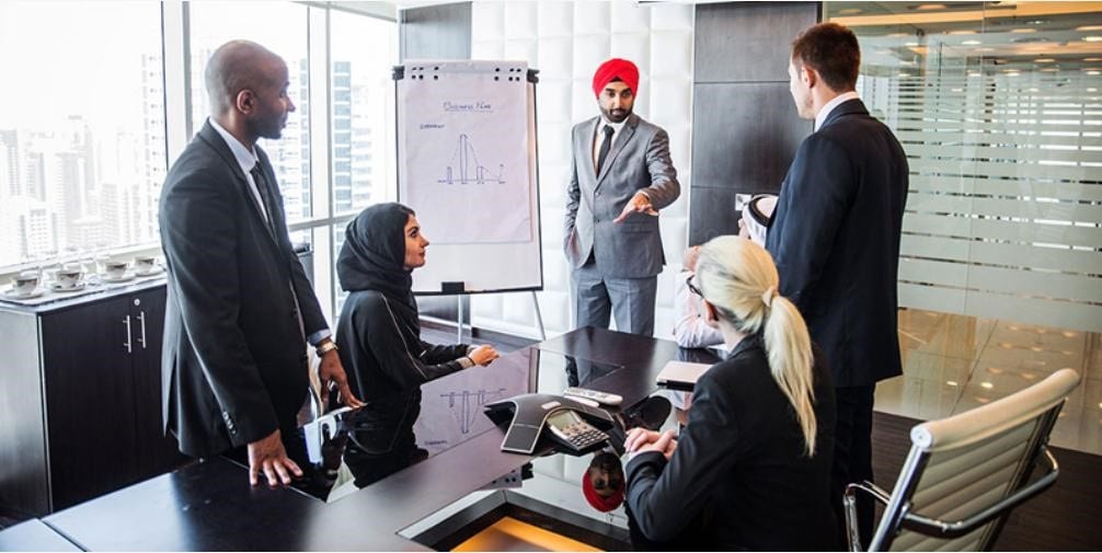Multicultural business people (including Gulf Arab woman) meeting and talking about business - credit Shutterstock